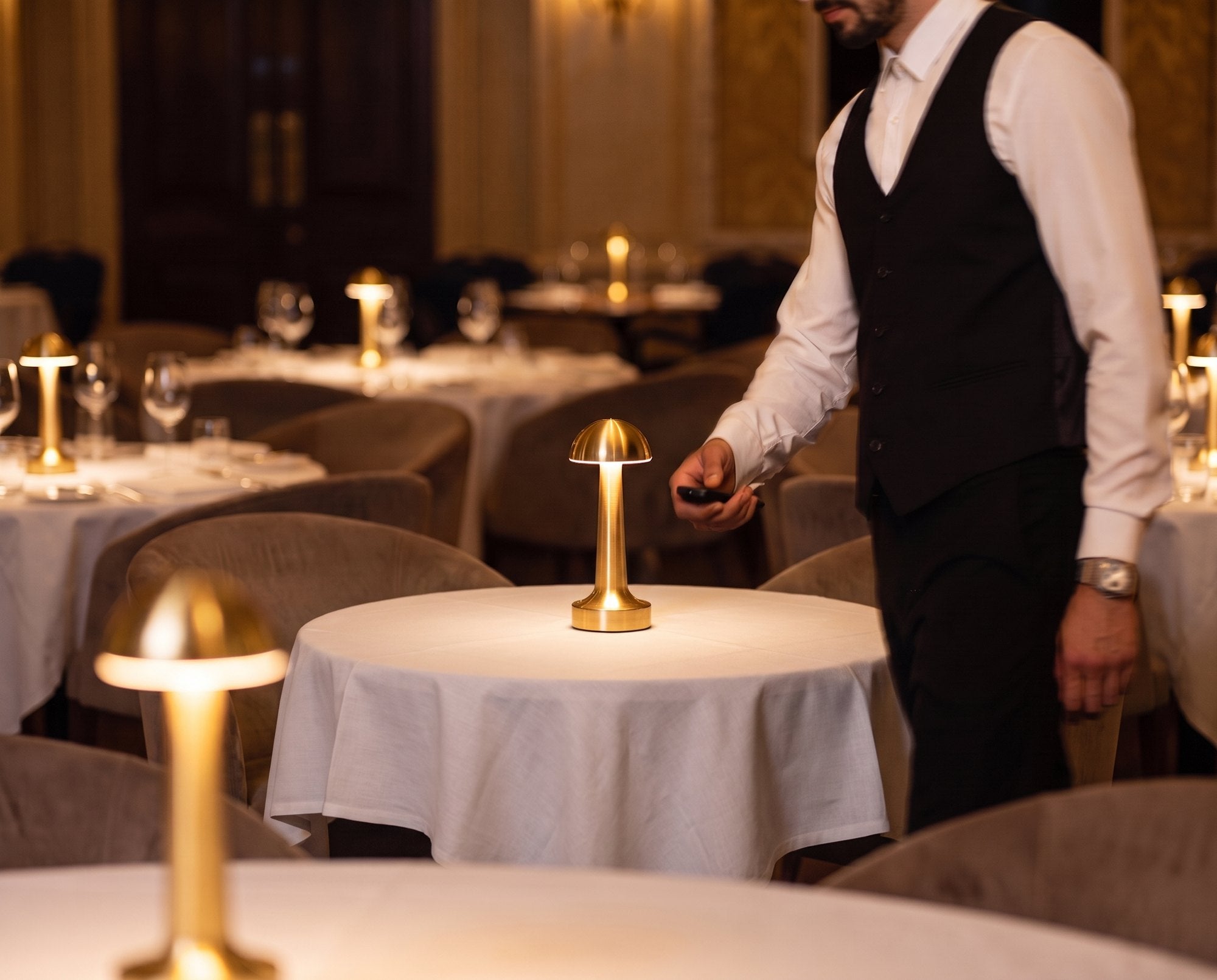 A server setting an Aveline on a laid table with the remote