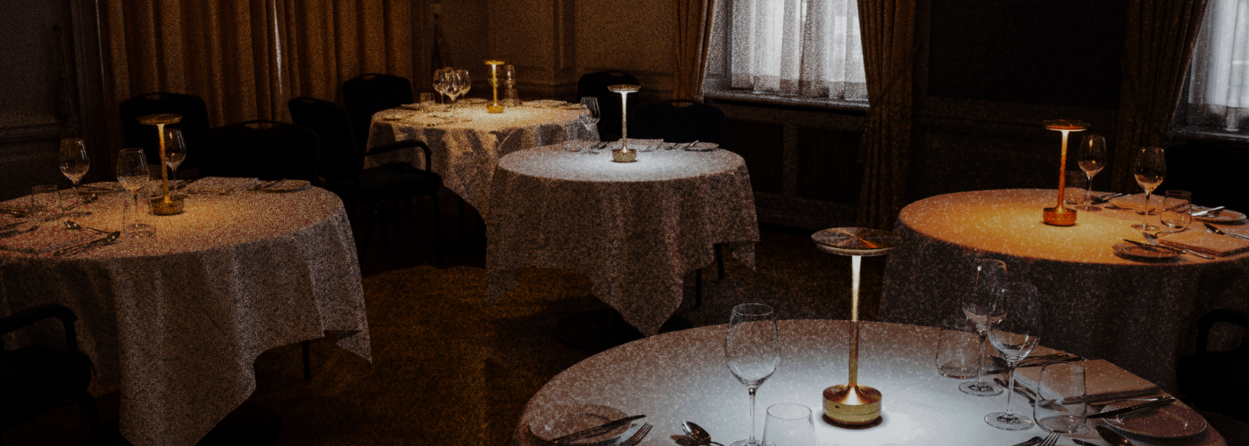 A dining room lit by a single warm table lamp