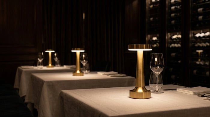 Brandende Clarté-lampen op gedekte tafels voor een wijnwand