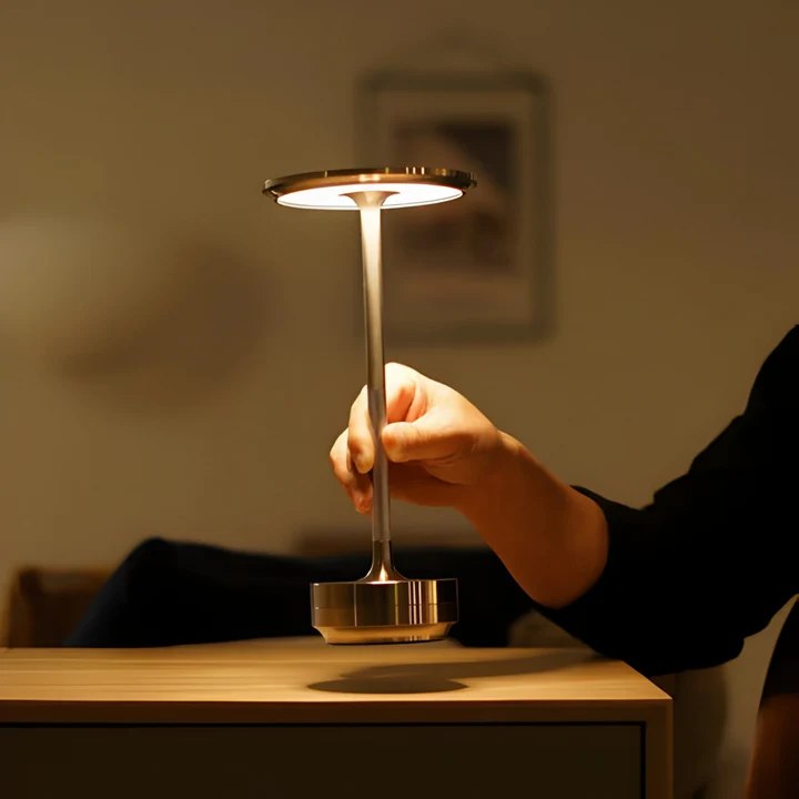 A hand reaching for a single table lamp at home.